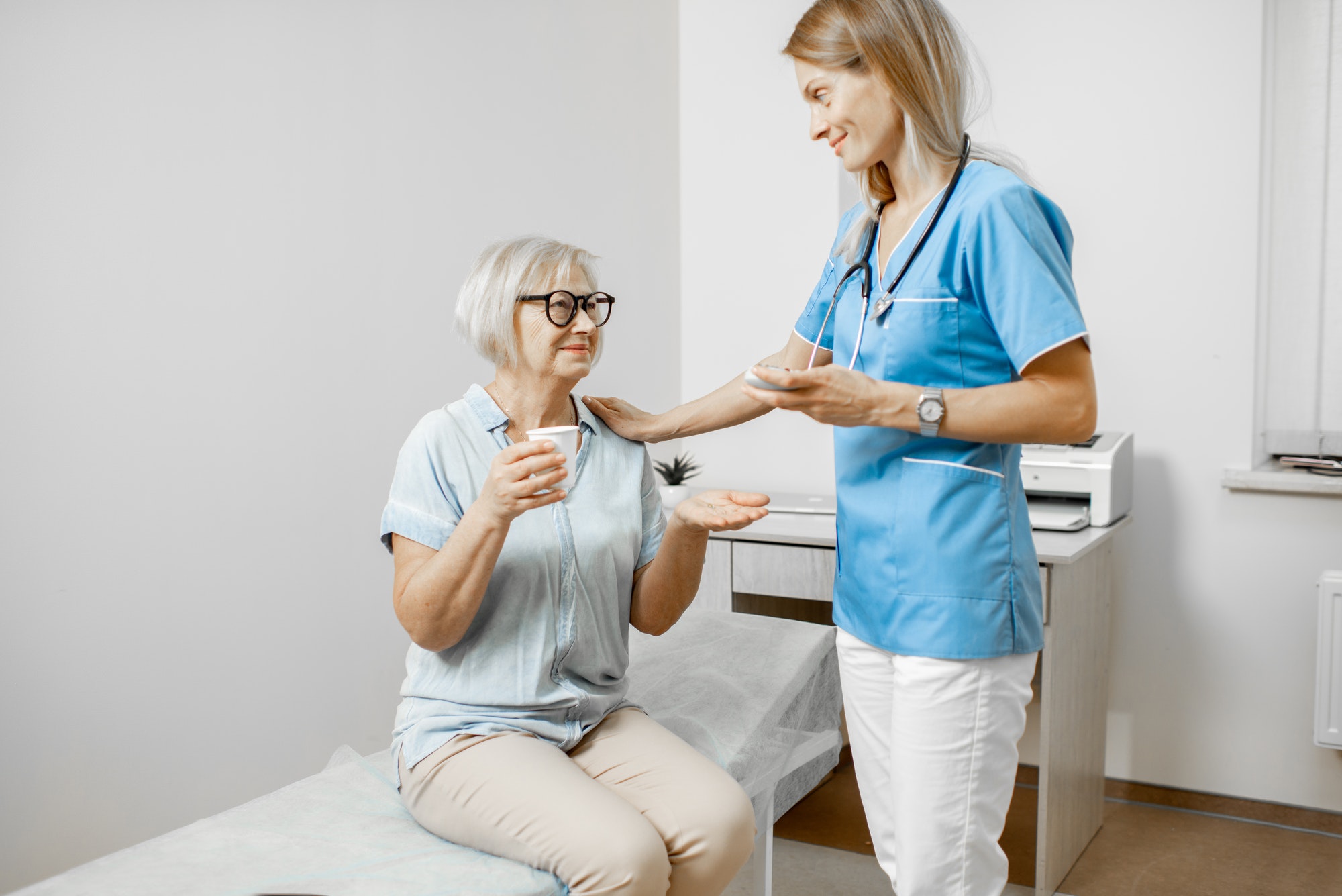 Nurse giving some medicine for a senior patient